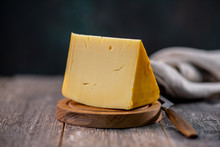Medium Hard Cheese Head Edam Gouda Parmesan On Wooden Board With Knife Wooden Texture Daylight