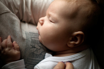 A mother holds a baby in her arms. A woman looks at a child with love. motherhood concept