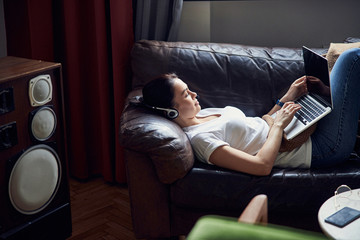 Wall Mural - Relaxed woman having rest at home and surfing Internet