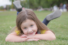 Portrait Of Girl Smiling While Lying On Field
