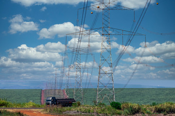 Power transmission tower in the middle of the sugar cane plantation, beautiful blue sky