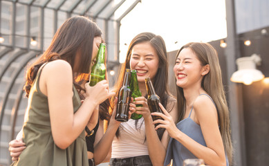  happy asian women holding bottle of beer chat together