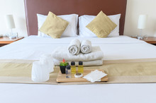 Group Set Of Free Hotel Amenities (such As Towels, Shampoo, Soap, Gel Etc) On The Bed. Hotel Amenities Is Something Of A Premium Nature Provided In Addition To The Room When Renting A Room.