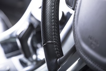 Canvas Print - Closeup shot of a black car's modern interior wheel - perfect for background