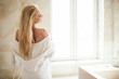 © JustLife - Beautiful woman wearing a bathrobe. Young happy woman enjoing in hotelroom.