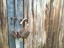 Close-up Of Rusty Padlock Hanging On Wooden Door