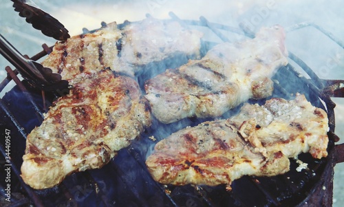 Fotografía Asando chuletones de cerdo ibérico en una barbacoa con carbón vegetal