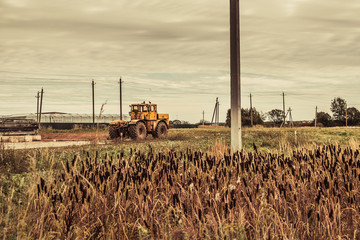 autumn countryside landscape, dirty road and farmland over sunset sky