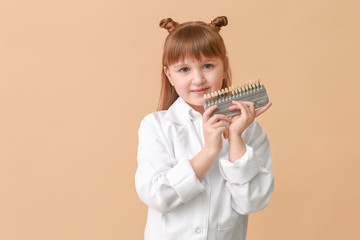 Sticker - Little dentist with teeth color samples on beige background