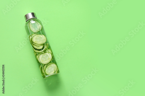 Fotomural Bottle of cucumber infused water on color background