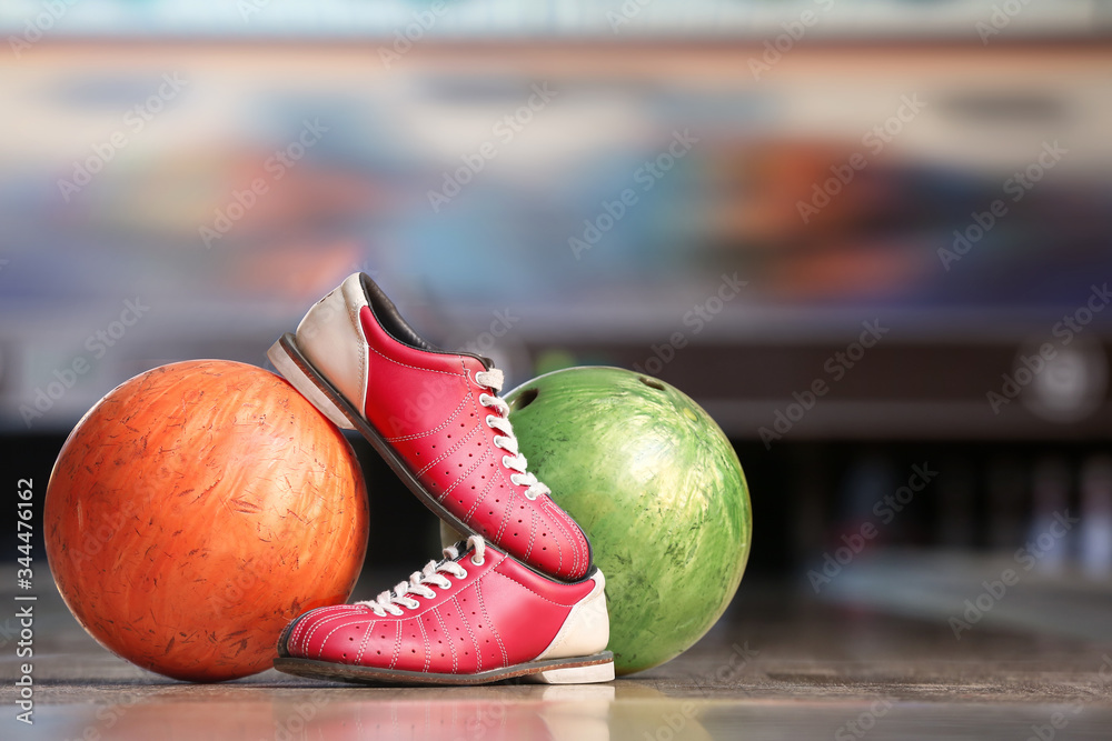 Shoes and balls on floor in bowling club
