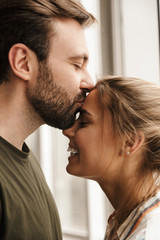 Canvas Print - Photo of romantic cute couple smiling and kissing while standing