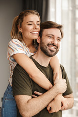 Wall Mural - Photo of romantic cute couple smiling and hugging while standing