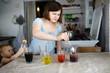 Child girl experiments with mixing colors at home