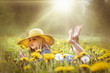 Kind mit Pusteblume liegt barfuß im Sommer auf einer gelben Blumenwiese 