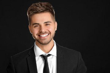 Poster - Portrait of handsome young businessman on dark background