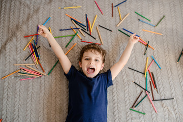 Happy little kid boy lying on the floor