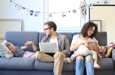 Wall Mural - Young beautiful happy family relaxing at home