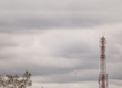 Telecommunication tower against cloudy sky with copy space