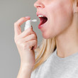 Woman using inhaler mouth spray for fresh breath
