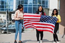 Three Young College African American Womans Friends With Flag Of USA.