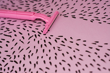 Pink background with marker drawn hairs and female razor for depilation.