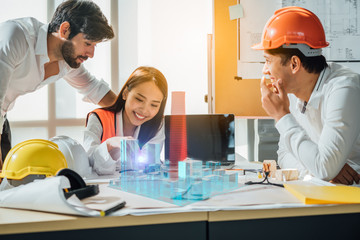 Smart Engineer and interior designer working renovation construction progress with smile and confident at desk with model home ,blue print and drawing tool at office site.