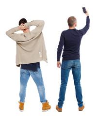 back view of two man in sweater with mobile phone.