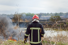 Raging Forest Spring Fires. Burning Dry Grass, Reed Along Lake. Grass Is Burning In Meadow. Ecological Catastrophy. Fire And Smoke Destroy All Life. Firefighters Extinguish Big Fire. Lot Of Smoke