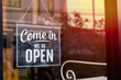 © Maderla - Text on vintage black sign 'Come in we're open' in door cafe.