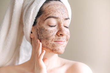 Spa mask at Home, young woman with towel on her head with scrub on her face