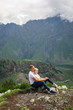 © Alexander - young beautiful couple travelers girl blonde in a white t-shirt, a man in a white t-shirt stand on a background of mountains in Georgia