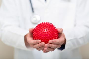 Medical doctor holding a virus in his hand