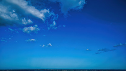 Wall Mural - Blue sky and multiple clouds background showing a horizon