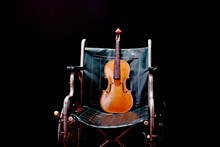 Close-up Of Violin On Chair Against Black Background