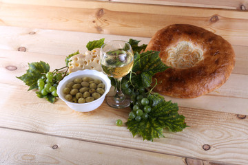 Canvas Print - Wine, grape, cheese, bread and olives on table