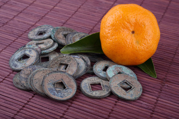 Canvas Print - Mandarin oranges and ancient Chinese coins on bamboo background. Symbols of luck and Chinese New Year.