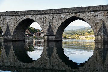 The Ottoman Mehmed Pasa Sokolovic Bridge over Drina river in Visegrad, Bosnian mountains, with fantastic  river reflection. Bosnia and Herzegovina.