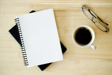 cup of hot coffee  on wooden background with notebook.  Work from home concept.