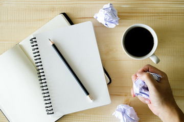 cup of hot coffee  on wooden background with notebook.  Work from home concept.