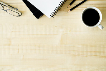 cup of hot coffee  on wooden background with notebook.  Work from home concept.