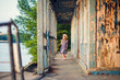 © andrey - little girl standing on porch of old ruined house.