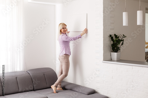 Fotografía woman holds photo canvas at home