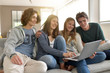 © goodluz - Friends having fun at home connected on laptop