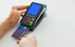 © wittaya - Paying with a credit card for a man's hand, put a credit card into a card reader to pay instead of cash.