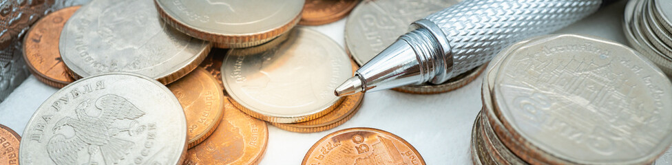 Stack of coins with pen using as background retirement, business financial money saving cover page Investment concept