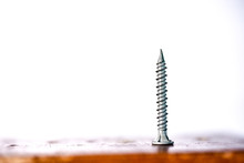 Close-up Of Screw On Wooden Table Against White Background
