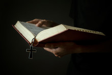 Midsection Of Woman Holding Bible With Cross Against Gray Background