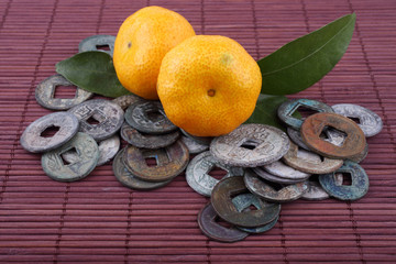 Canvas Print - Mandarin oranges and ancient Chinese coins on bamboo background. Symbols of luck and Chinese New Year.