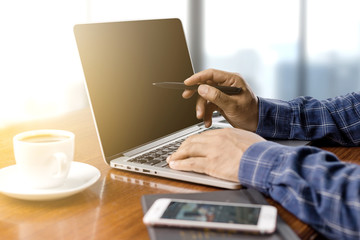 Wall Mural - businessman working with modern workplace with laptop on wood table, Man hand on laptop keyboard for work from home, Overhead view of businessman working  in office